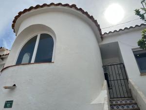a white building with a window on the side of it at Apartamento cerca de la playa in Denia