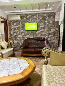 salon ze skórzaną kanapą i telewizorem w obiekcie Nador cornich Apartement w mieście Nador