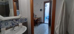 a bathroom with a sink and a mirror and a table at Casetta Colorata in Bagheria