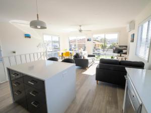 a kitchen and living room with a white counter top at Mermaid Apartments in Merimbula