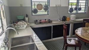 een keuken met een wastafel en een aanrecht met potten en pannen bij Ayana Homestay in Labuan