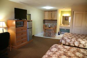 una camera d'albergo con due letti e una televisione di Coach Light Inn a Brenham