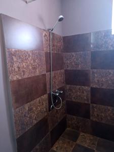 a bathroom with a shower with brown tiles at Guest House Temi In Gudani 
