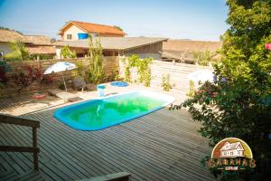 a swimming pool on top of a wooden deck at Cabana Canadense, Vem Relaxar e Desconectar in Imaruí