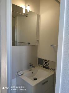 a white bathroom with a sink and a mirror at Studio Tribord Le Tréport - vue mer & falaises in Le Tréport +6 photos