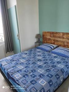 a bedroom with a bed with a blue and white quilt at Studio Tribord Le Tréport - vue mer & falaises in Le Tréport