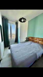 a bedroom with a bed with a blue wall at Studio Tribord Le Tréport - vue mer & falaises in Le Tréport