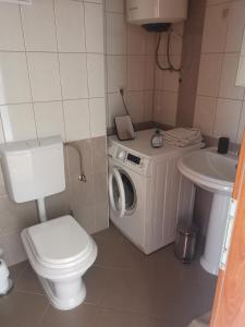 y baño con aseo, lavadora y lavamanos. en Apartment Croatika on the Beach, en Trogir
