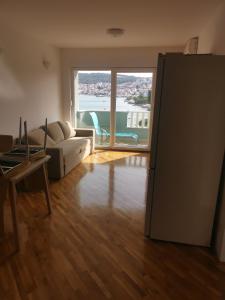 ein Wohnzimmer mit Couch und großem Fenster in der Unterkunft Apartment Croatika on the Beach in Trogir + 6 Fotos