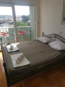 1 cama con 2 sillas y una ventana grande en Apartment Croatika on the Beach, en Trogir