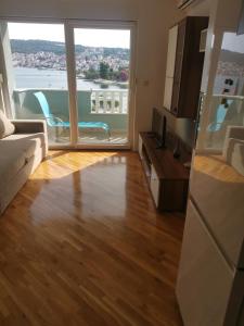 ein Wohnzimmer mit Couch und großem Fenster in der Unterkunft Apartment Croatika on the Beach in Trogir