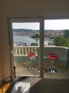 1 dormitorio con balcón con vistas al agua en Apartment Croatika on the Beach, en Trogir