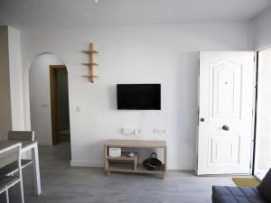 ein Wohnzimmer mit einem TV an einer weißen Wand in der Unterkunft Apartamento Urb. Playasol en Puerto de Mazarrón in Puerto de Mazarrón