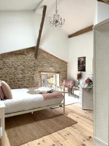 ein Schlafzimmer mit einem Bett und einer Ziegelwand in der Unterkunft Figtrees in Margueron