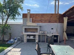 un patio con mesa, sillas y chimenea en فلل ليليان الحديثة en Jericho