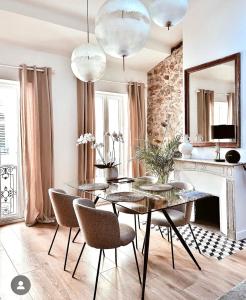 a dining room with a table and chairs and a fireplace at L appartement de Manon, centre historique du vieil Antibes in Antibes