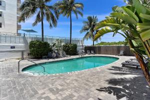 einen Pool im Innenhof mit Palmen in der Unterkunft Ocean Drive direct beach access South of Fifth Apartment in Miami Beach