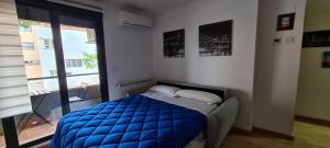 a bedroom with a bed with a blue comforter and a window at El Llano 3 in Puebla de Alfindén