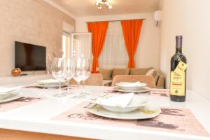 特雷比涅Apartman Darija 2的桌子上放着一瓶酒和一些酒杯