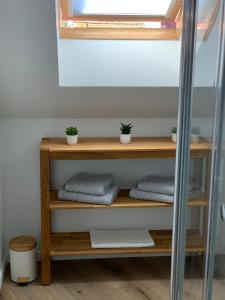 a shelf with three towels and a window at Chez Aline & Seb in Boulogne-sur-Mer