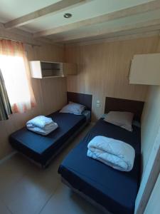 dwa łóżka w małym pokoju na łodzi w obiekcie 6/8 pax COTTAGE - Oasis Village w mieście Puget-sur Argens