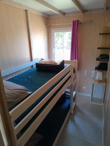 Ce lit superposé se trouve dans une petite chambre dotée d'une fenêtre. dans l'établissement 6/8 pax COTTAGE - Oasis Village, à Puget-sur Argens