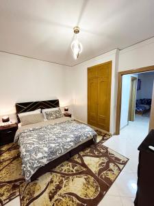 1 dormitorio con cama y alfombra en SAM HOUSE 2 min à l'aéroport en Tánger