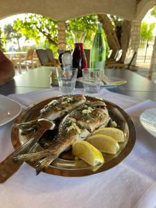 a fish on a plate with lemons on a table at Bed&Breakfast Drage in Drage +42 photos