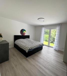 ein Schlafzimmer mit einem Bett und einem großen Fenster in der Unterkunft Ferienwohnung: Waldblick in Hatten