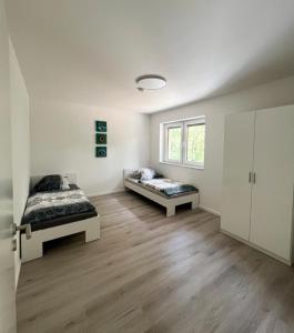 biały pokój z 2 łóżkami i oknem w obiekcie Ferienwohnung: Waldblick w mieście Hatten