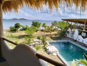 a swimming pool with a view of the ocean at SHAYA cottage in Sekotong
