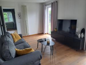 sala de estar con sofá y TV en Sherlock's Home - Guest House, en Namur