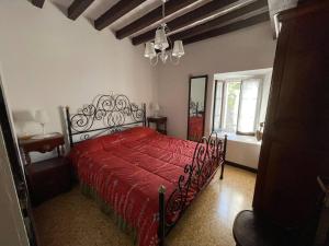 1 dormitorio con cama roja y edredón rojo en Ca' del Conte, 