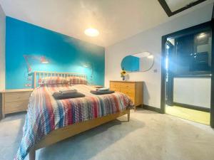 Un dormitorio con una cama y una pared azul. en Farne Island rooms, en Seahouses