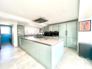 a large kitchen with green cabinets and a large island at Farne Island rooms in Seahouses