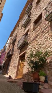 um edifício de tijolos com uma porta amarela e janelas em Casa Pastor em Villafamés