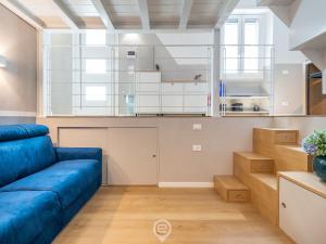 a living room with a blue couch and a kitchen at Is Arenas Biancas Apartment in Teulada