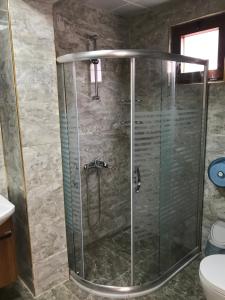 La salle de bains est pourvue d'une douche avec une porte en verre. dans l'établissement Danis Otel Ve Restoran, à Uzungöl