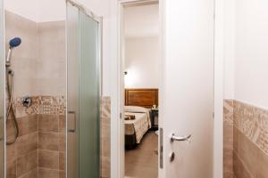 łazienka z prysznicem i sypialnia w obiekcie Domo Mediterranea Affittacamere-Guest House w mieście SantʼAntìoco