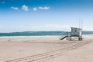 a life guard shack on a beach with the ocean at The Canford in Poole