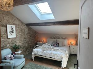 a bedroom with a white bed and a skylight at Figtrees in Margueron