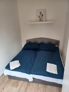 Una cama azul con dos toallas blancas. en Chatka Obláčik, en Diakovce