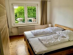 a bedroom with two beds and a window at Ostseenahes Traumhaus am Kiel-Kanal in Schleswig-Holstein - Zum Ostseestrand in zehn Minuten in Altenholz