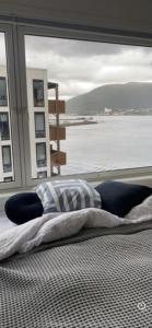 a bed in a room with a large window at Seaside panorama in Tromsø