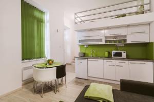 una cocina con armarios blancos y una pared verde en Stex Loft Apartment in the city center, en Budapest