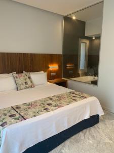a bedroom with a bed and a large mirror at Petra Hotel in Agia Galini