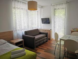 a bedroom with a bed and a couch and a table at Villa Veell - tylko 4 minuty od pięknej szerokiej plaży in Pobierowo