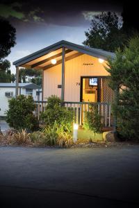 una pequeña casa con puerta amarilla y porche en Airport Tourist Village Melbourne en Melbourne