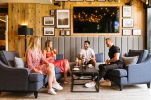 a group of people sitting in a living room at MONDI Resort und Chalet Oberstaufen in Oberstaufen