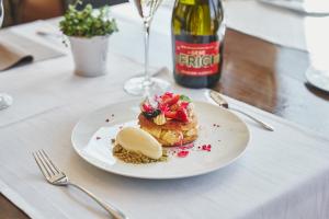 Crocus Gere Bor Hotel Resort & Wine Spa في فيلاني: طبق من الطعام على طاولة مع زجاجة من النبيذ